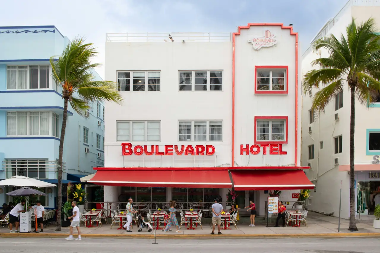 Boulevard Hotel with sidewalk café and palm trees.